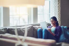 Women reading on iPad while sitting on a couch